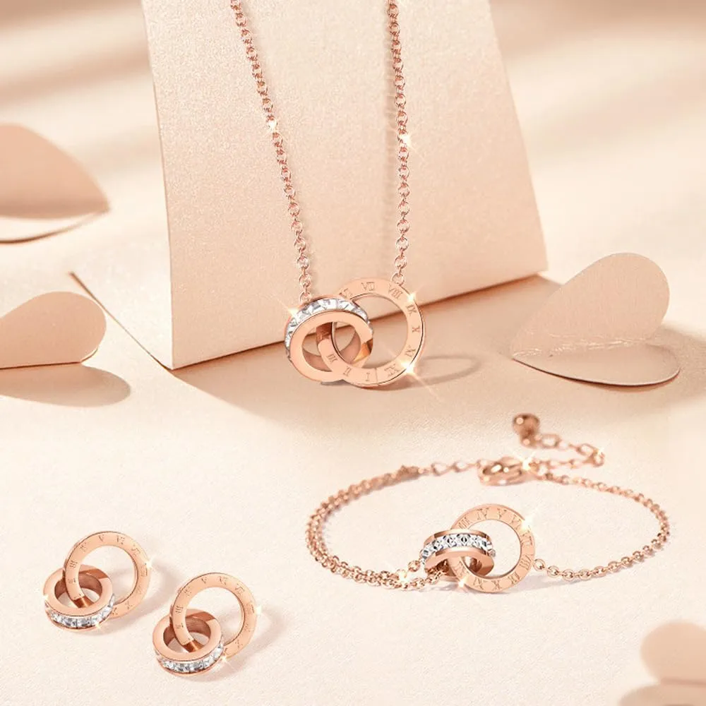 RPAEOY Set Gioielli Numeri Romani in Acciaio Inossidabile Placcato Oro 18K con Zircone, Collana, Orecchini e Bracciale (Oro Rosa) - immagine 2